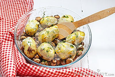 Roasted young potatoes in glass baking dish with a mushrooms Stock Photo