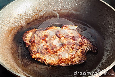 Roasting beef steak in frying pan on range Stock Photo