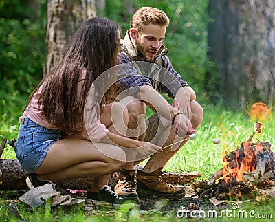 Roasting marshmallows popular group activity around bonfire. Couple friends prepare roasted marshmallows snack nature Stock Photo