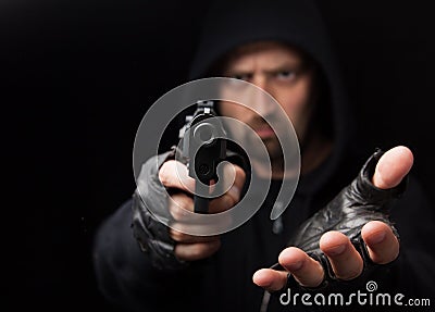 Robber with gun holding out hand Stock Photo