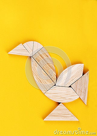 Robin redbreast figure is assembled from pieces of a tangram puzzle game over a yellow background Stock Photo