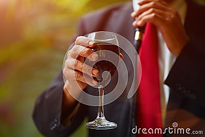 Rabbi holds kiddish cup with wine in front of Groom and Bride Stock Photo