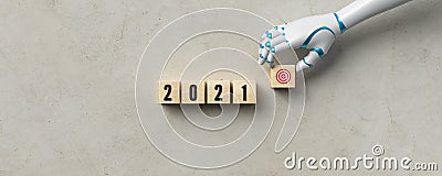 Robot hand adding a cube with a goal symbol to other cubes with message 2021 Stock Photo