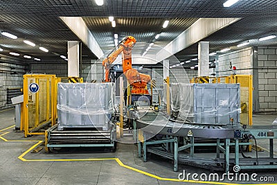 Robot Hand manipulator packaging factory products from conveyor into container Stock Photo