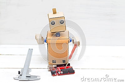 The robot holds a red screwdriver and a printed circuit board in Stock Photo