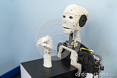 A robot with a human face, a mechanical arm, a bionic arm. Exhibition on robotics-Robo Stars a festival of robots Editorial Stock Photo