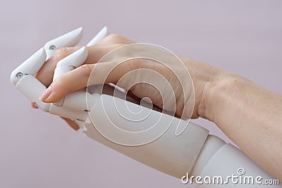 Robot and human fingers are intertwined. Love and passion between machine and man. Or a relationship with a disabled Stock Photo