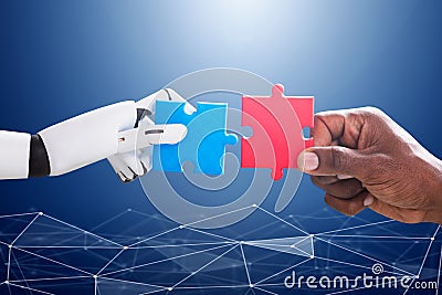 Robot And Human Hand Joining Jigsaw Stock Photo