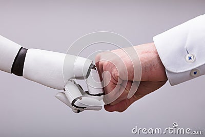 Robot And Human Hand Making Fist Bump Stock Photo