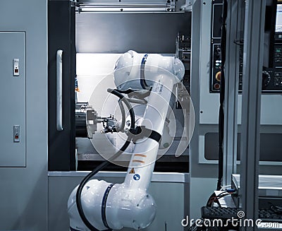 Robot loading workpiece to CNC machine Stock Photo