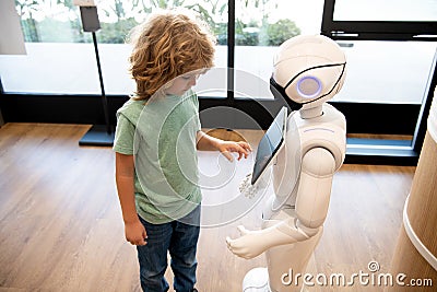 robot provide assistance to child. automation. artificial intelligence interact with boy Stock Photo