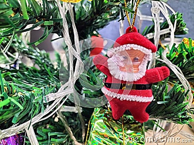 Robot Santa Christmas ornament on green Christmas tree with firetruck ornament in background Stock Photo