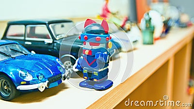 The robot is standing in front of his blue car. Stock Photo