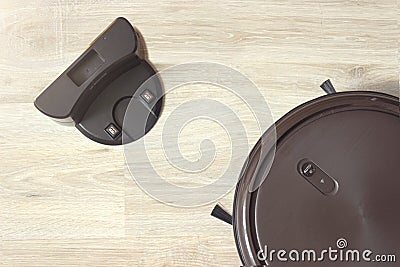 Robot vacuum cleaner on charging dock after it is finished. Modern smart electronic housekeeping technology.Indoor, housework Stock Photo