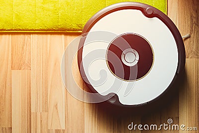 Robot vacuum cleaner on laminate wood floor with carpet cleaning Stock Photo