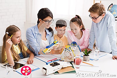 Robotic class. Pupils working with teacher on robot project Stock Photo