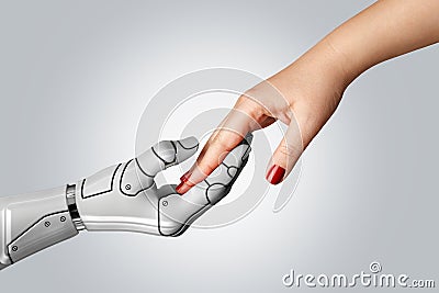 Robotic cyborg hand holding female human hand Stock Photo