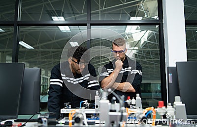 The robotic hand technology teacher is instructing new students on how to use electronic circuit boards and robotic hand commands Stock Photo