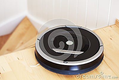 robotic vacuum cleaner on laminate wood floor smart cleaning technology stairs Stock Photo