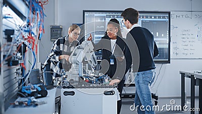 In Robotics Development Laboratory: Black Female Teacher and Two Students Work With Prototype of Stock Photo