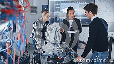 In Robotics Development Laboratory: Black Female Teacher and Two Students Work With Prototype of Stock Photo