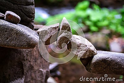 Rock bridge, pyramid, rock balancing art. Close-up of a stack of stones in perfect balance in a mountain forest. Stock Photo