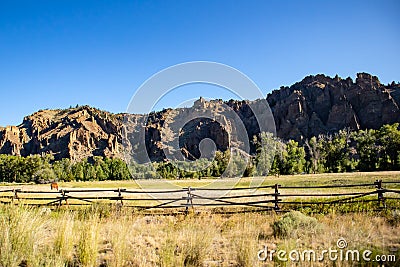 Rock cliffs and a pature with horses on it in Wyoming Stock Photo