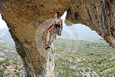 Rock climber hanging on rope Stock Photo