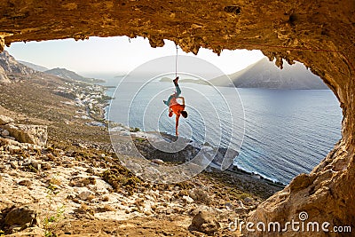 Rock climber hanging on rope after falling of cliff, climbing in cave Stock Photo