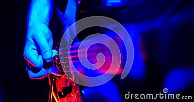 Rock concert. Guitarist plays the guitar. The guitar illuminated with bright neon lights. Hand close up Stock Photo