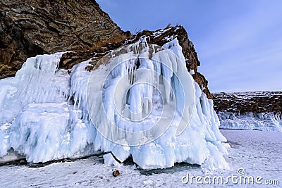 Rock covered with icicles. Lake Baikal in cloudy weather. Stock Photo