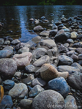 Rock covered riverbank Stock Photo