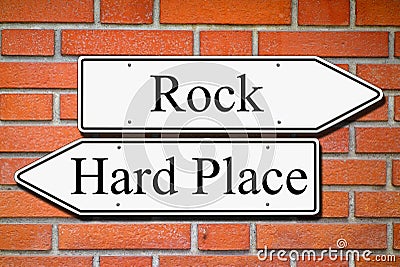 Between rock and hard place signpost concept brick wall Stock Photo