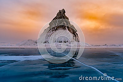 Rock mountain on freezing water lake with sunset sky background Stock Photo