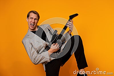 rock & x27; n & x27; roll guy, a cool guy with a fake guitar, pretends to play music. Fun and emotion. Stock Photo