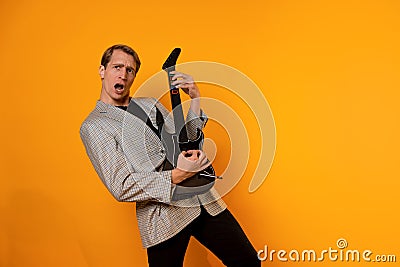 rock & x27; n & x27; roll guy, a cool guy with a fake guitar, pretends to play music. Fun and emotion. Stock Photo