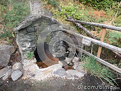 Rock shelter over natural hot spring Stock Photo