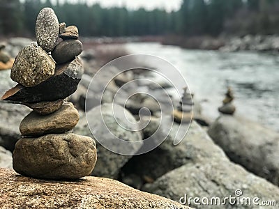 Rock stacks near river lined with pine trees Stock Photo