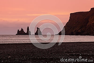 Rock Troll`s fingers in the ocean near the beach with black sand Stock Photo