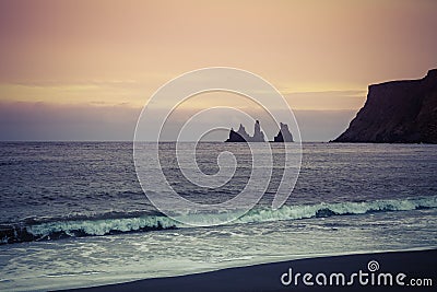 Rock Troll`s fingers in the ocean near the beach with black sand Stock Photo