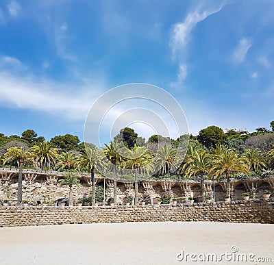Rock walkway with stone columns with palm garden in famous Park Guell Stock Photo