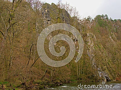 Rock wall with trees along Ourthe river, Liege, Belgium Stock Photo