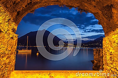 Rock window over tranquil lake Como at dusk Stock Photo