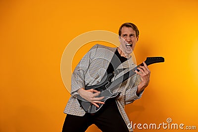 rock & x27; n & x27; roll guy, a cool guy with a fake guitar, pretends to play music. Fun and emotion. Stock Photo