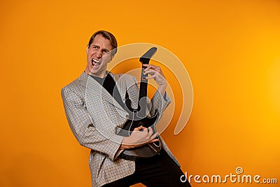 rock & x27; n & x27; roll guy, a cool guy with a fake guitar, pretends to play music. Fun and emotion. Stock Photo