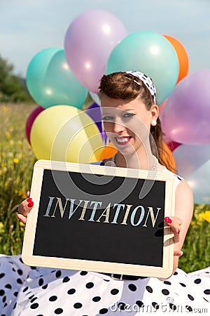 Rockabilly Girl holding a board with word invitation, concept Party Stock Photo