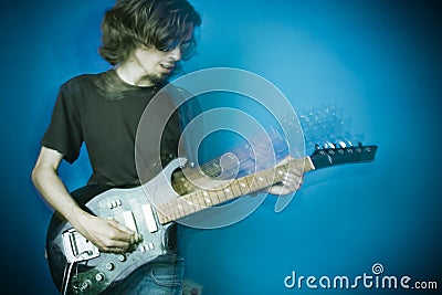 Rocker playing guitar on blue Stock Photo