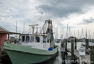 ROCKPORT, TX - 3 FEB 2020: Green and white shrimp boat at a wooden dock Editorial Stock Photo