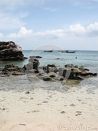 Rocks on Beach with Boats Stock Photo