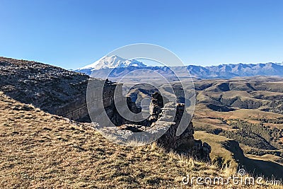 rocks of Bermamyt Plateau and view of Mount Elbrus Stock Photo